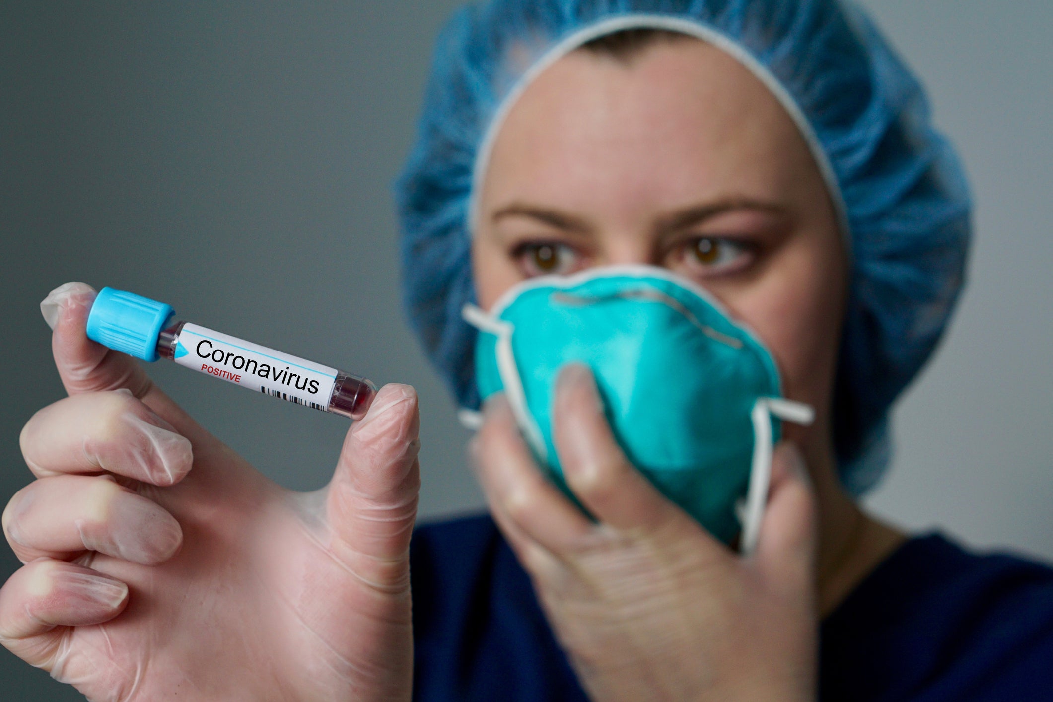 nurse holding vial with coronavirus label positive case