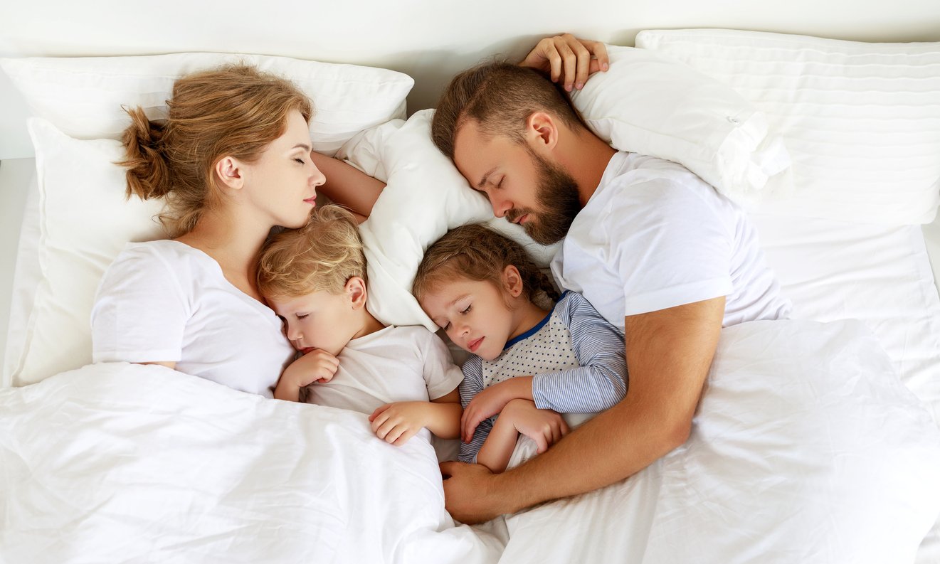 healthy sleep. happy family parents and children sleeping in white bed Συγκοίμηση, υπνοΣ, ψυχολογία