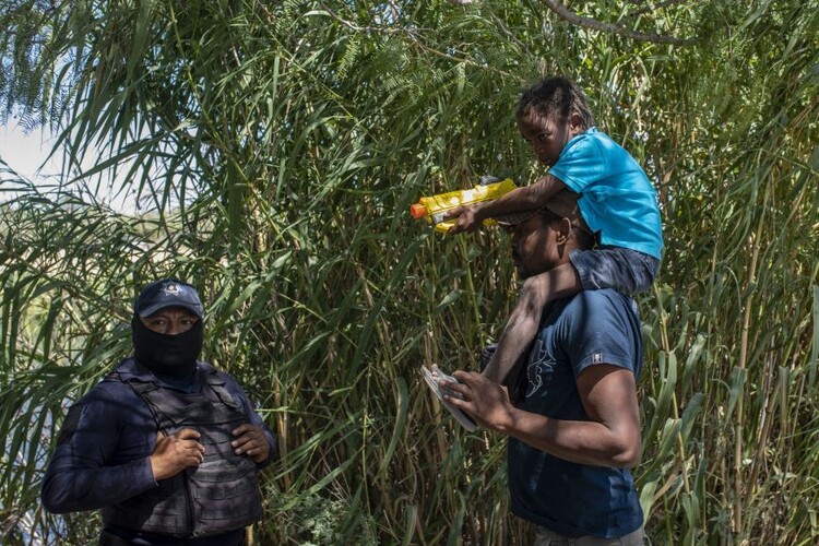 Αϊτινός μετανάστης με το παιδί του