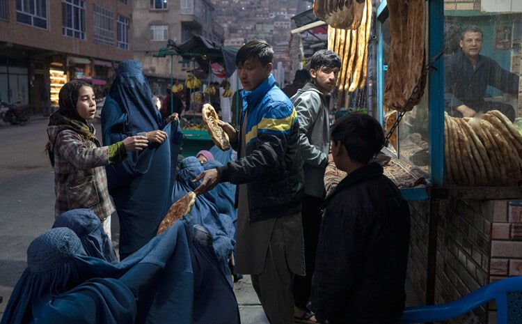 Мужчина раздает хлеб в Афганистане