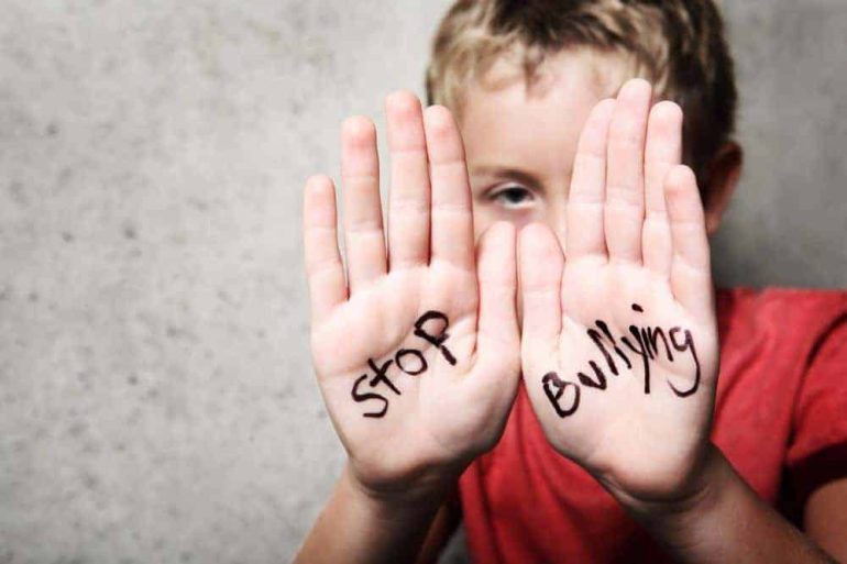 A boy with the phrase 22stop bullying22 written on his hands Τοπικα