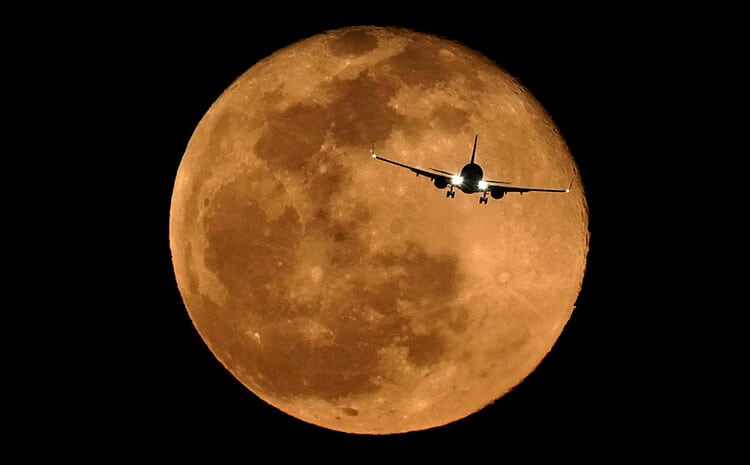 An airplane with a moon background