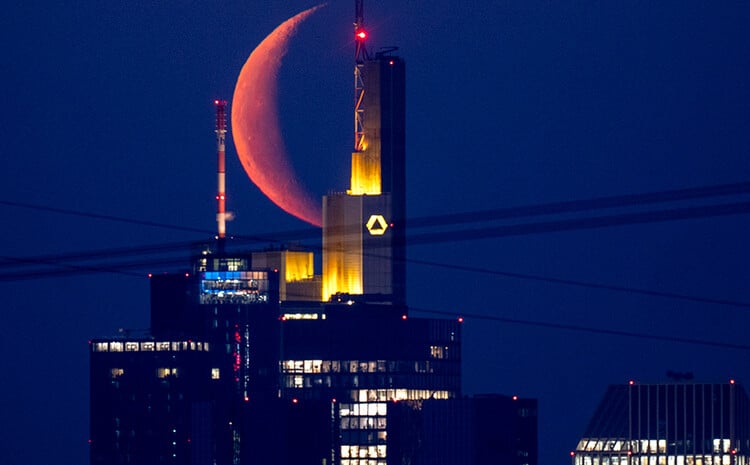 The moon behind a building