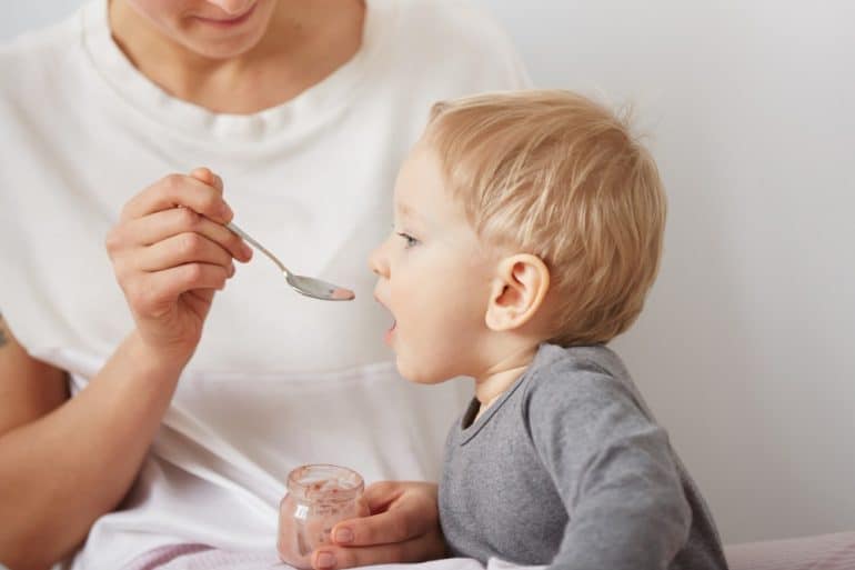 mother feeding her baby boy with spoon Child