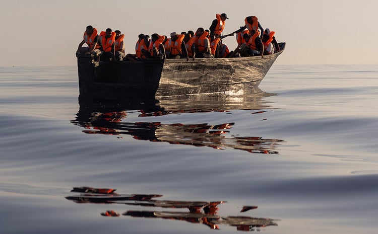 Migrants with life jackets in a boat